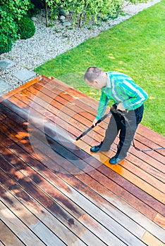 Power washing - man cleaning terrace with a power washer - high water pressure cleaner on terrace surface