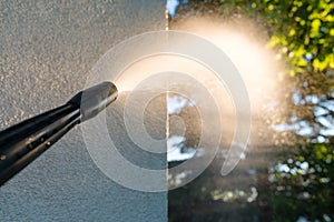 Power washing the wall - cleaning the facade of the house - focus on the tip of the spray nozzle