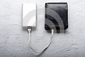 Powerbank and leather wallet. Replenish the wallet. Refueling with energy. Conceptual photo