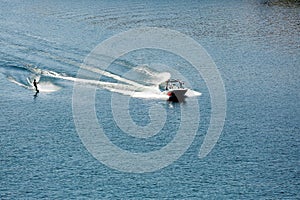 A powerboat pulling a water skier on a lake.