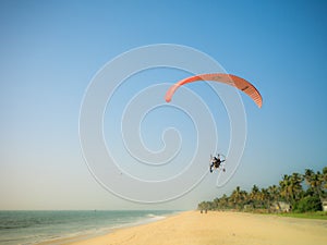 Powered paraglider in flight in India, on Alappuzha beach.