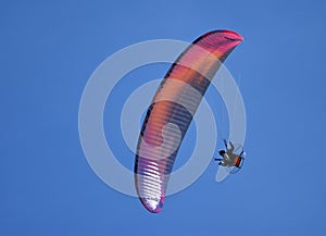 Powered paraglider flying over the blue sky