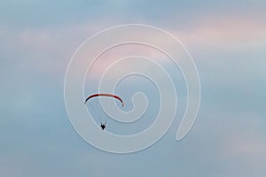 Powered paragliding, man flying high in a sky with parachute and engine on his back