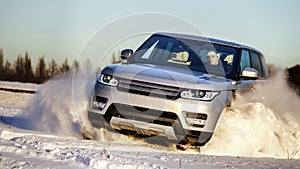 Powerful 4x4 offroader car running on snow field