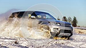 Powerful 4x4 offroader car running on snow field