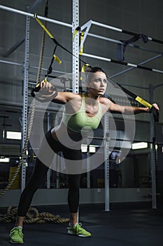 Powerful attractive muscular woman CrossFit trainer working out at gym