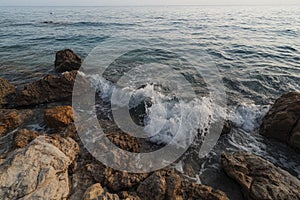 Powerful blue waves crashing on rocky shore