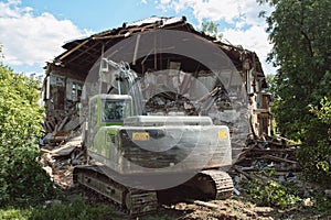 Powerful crawler excavator demolishes an old building