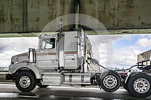 Powerful day cab white big rig semi truck tractor with semi trailer with oversize load sign running on the transportation two