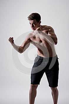 Powerful fighter man in fighting stance on white background