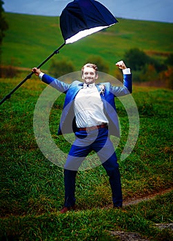 Powerful groom in action hero pose under a light of stroboscope.