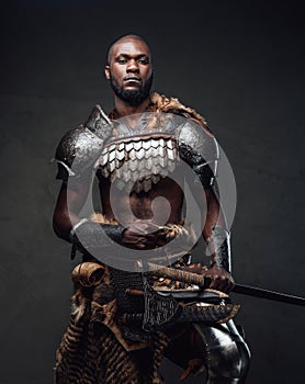 Powerful and handsome authentic soldier wearing armor with axe