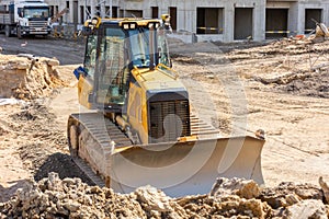 Powerful heavy crawler bulldozer works at a construction site