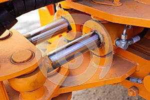 Powerful hydraulic pumps that stand in the bucket of an excavator, industry, close-up, orange