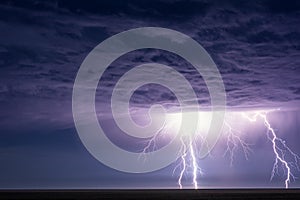 Powerful lightning bolts strike from a summer thunderstorm. photo