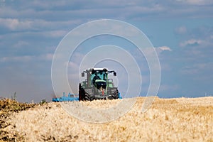 Powerful modern machine for harvesting from the field.  Golden field of ears, barley, wheat and rye, harvesting equipment against