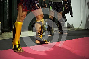 Powerful Muay Thai fighters' legs, shielded by shin guards.