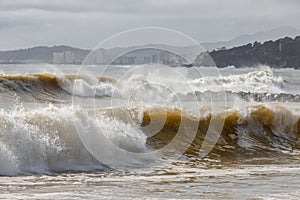 Powerful ocean wave breaking ina windy day