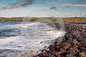 Powerful ocean wave crushes on stone shore.