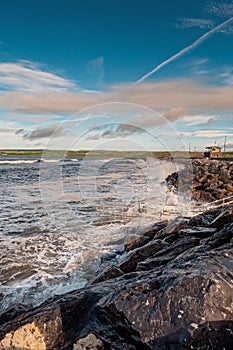 Powerful ocean wave crushes on stone shore. West coast of Ireland, Lahinch town, county Clare.