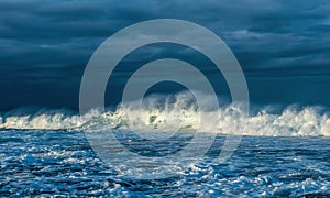 Powerful ocean wave on the surface of the ocean. Wave breaks on a shallow bank. Stormy weather