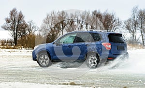 Powerful offroader car sliding by lake ice