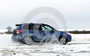 Powerful offroader car sliding by lake ice