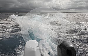 Powerful outboard motors of a speedboat fleeing a storm, selective focus