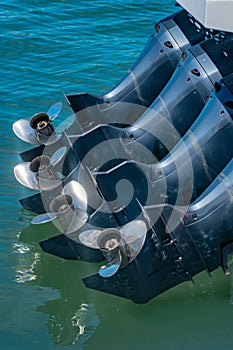 4 powerful propellor engines on the hull of a boat photo