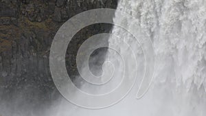 Powerful raging whitewater waterfall falling forcefully over a rocky edge. Crystal clear glacier water stream dropping over the cl