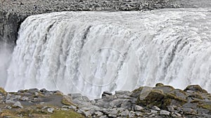 Powerful raging whitewater waterfall falling forcefully over a rocky edge. Crystal clear glacier water stream dropping over the cl