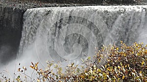 Powerful raging whitewater waterfall falling forcefully over a rocky edge. Crystal clear glacier water stream dropping over the cl