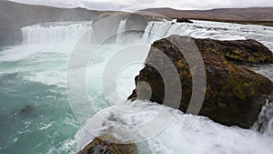 Powerful raging whitewater waterfall falling forcefully over a rocky edge. Crystal clear glacier water stream dropping over the cl