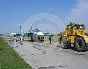 Powerful Russian military jet fighter plane on the runway of the SU-34 tractor carries engine