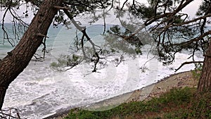Powerful sea waves are crashing on the Black Sea coast. Waves splash on the beach with pebbles during a storm. Storm at