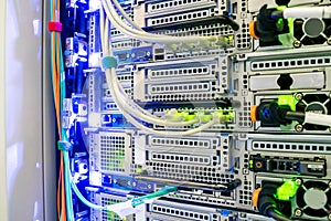 Powerful servers are close-up. A bundle of wires is connected to the computer equipment in the data center server room