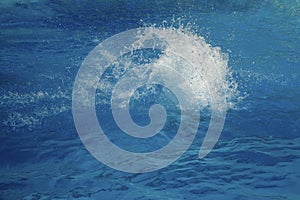 Powerful splash on a blue water surface with waves and splashes