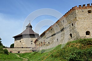 A powerful stone wall of a medieval fortress with many loopholes and embrasures