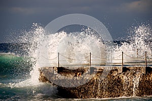 Powerful Stunning Wave Crashing Against Outdoor Pool.