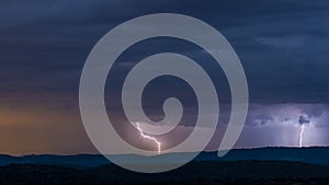 Powerful thunderstorm over hills at night