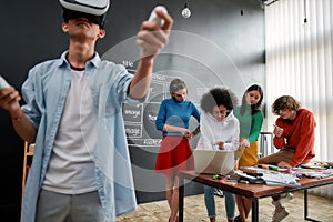 Powerful tool for business. Young asian man in casual clothes wearing wearing virtual reality headset while his