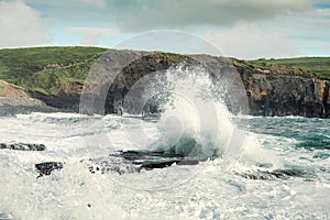 Powerful waves crushing against Cliffs and rough stone coastline of West coast of Ireland. Doolin area. County Clare. Ocean power