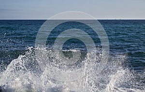 Powerful Waves crushing on a rocky beach and the foam and water spray appears