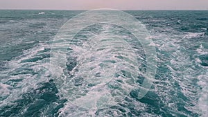 Powerful waves following the ship. Track from the engines of the ship. Cruise liner sails on the blue ocean. Waves behind the ste