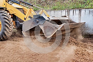 Powerful wheel loader or bulldozer at the construction site. Loader transports sand in a storage bucket. Powerful modern equipment