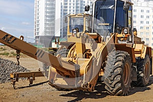 Powerful wheel loader for transporting bulky goods at the construction site of a modern residential area. Construction equipment