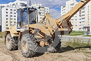 Powerful wheel loader for transporting bulky goods at the construction site of a modern residential area. Construction equipment