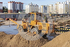 Powerful wheel loader for transporting bulky goods at the construction site of a modern residential area. Construction equipment