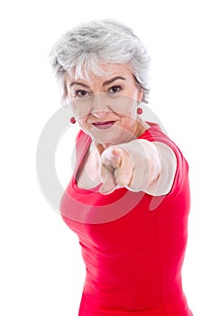 Powerful woman in red isolated with gray hair pointing with finger