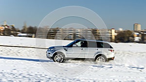 Powerful 4x4 offroader car running on snow field